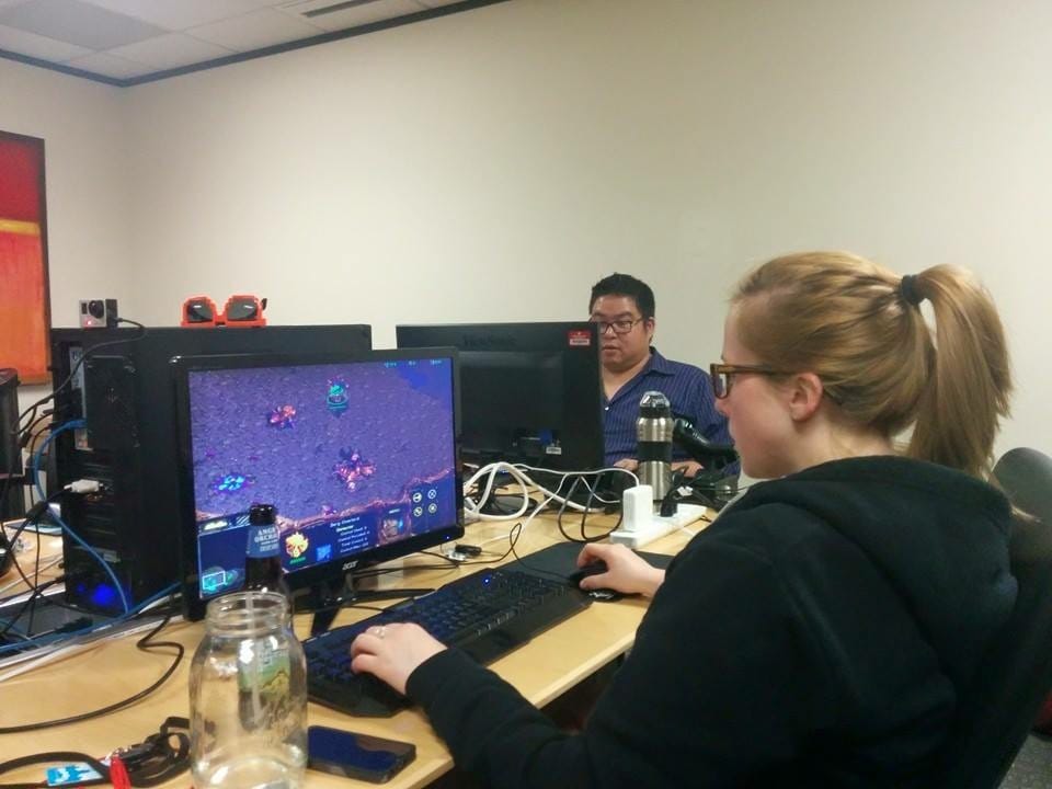Image of Ellen sitting at a conference table having a LAN party playing StarCraft.