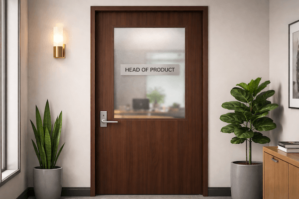 Office hallway with a wood door at the end. The door has a window and on the window is a sign reading "head of product."