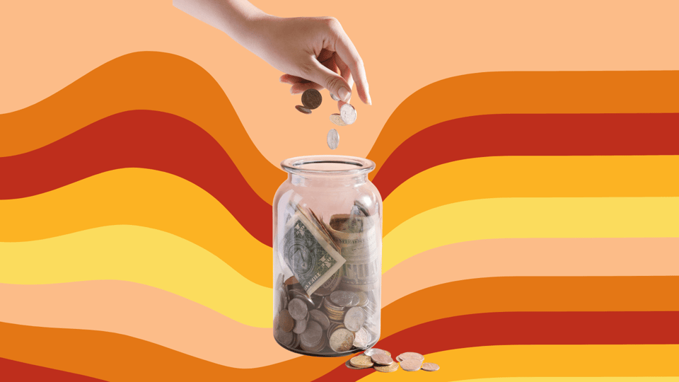 A hand drops coins into a glass jar already holding dollar bills and loose change, with a few more coins resting at its base. Wavy retro stripes in orange, red, and yellow fill the background.